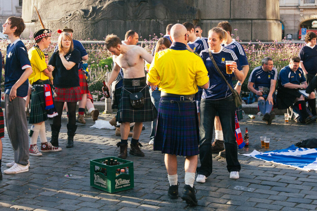 Foreign tourists socialising in Old Town Prague, surrounded by historic buildings and cobblestone streets