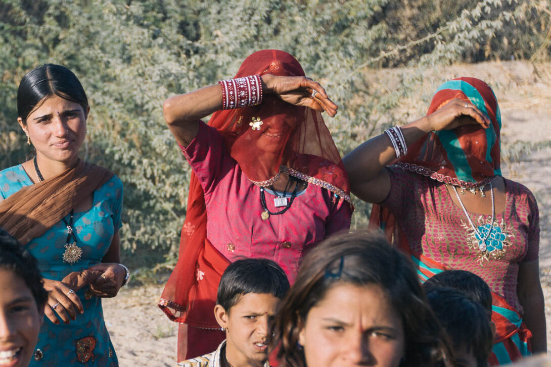 Photo of tribal women and children dressed in beautiful clothes in the Thar Desert in Rajasthan